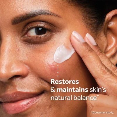 Close up of a hand applying cream to a cheek with a blemish Restores & maintains skins natural balance *Consumer study.