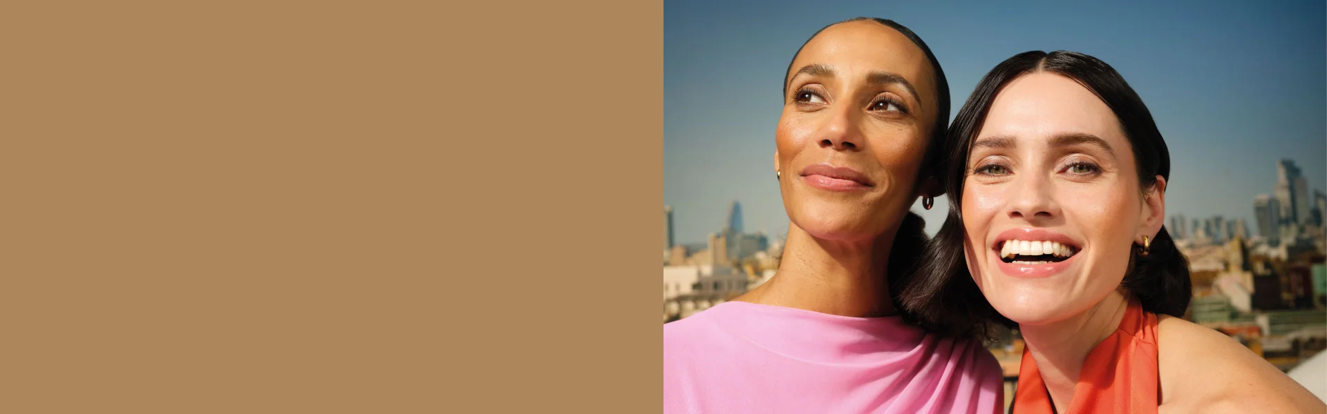 Two women smiling on a rooftop