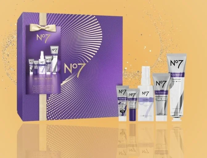 Image features the No7 Retinol Sleep Collection on a gold background with a reflection and silver glitter behind the gift set