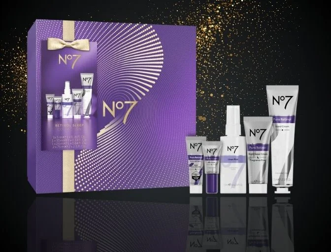 Image features the No7 Retinol Sleep Collection on a black background with gold glitter behind the gift